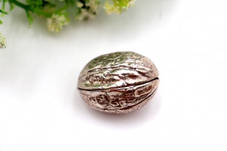 Caixa de comprimidos em prata em forma de noz em vulto perfeito